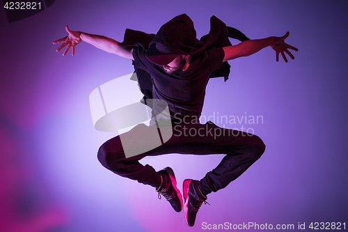 Image of The silhouette of one hip hop male break dancer dancing on colorful background