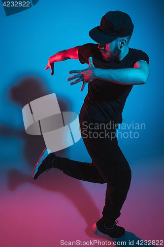 Image of The silhouette of one hip hop male break dancer dancing on colorful background