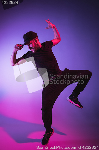 Image of The silhouette of one hip hop male break dancer dancing on colorful background