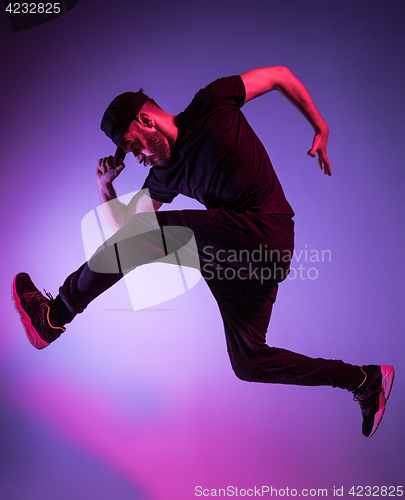 Image of The silhouette of one hip hop male break dancer dancing on colorful background