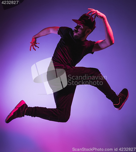 Image of The silhouette of one hip hop male break dancer dancing on colorful background