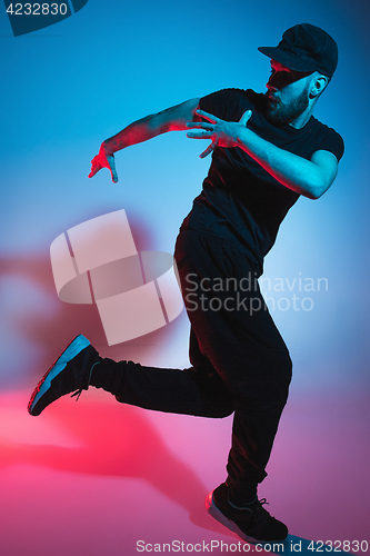 Image of The silhouette of one hip hop male break dancer dancing on colorful background