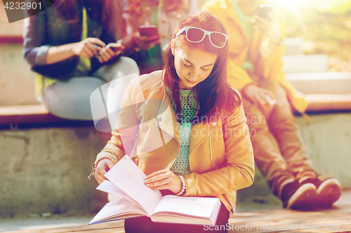 Image of high school student girl reading book outdoors