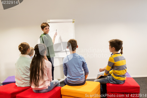 Image of student boy with marker writing on flip board