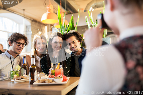 Image of friends with camera photographing at bar or cafe