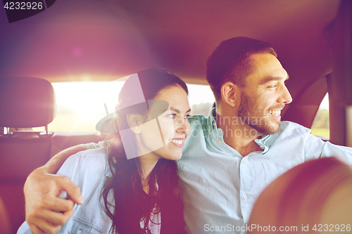 Image of happy man and woman hugging in car