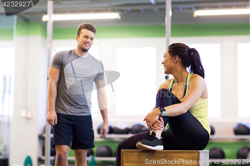 Image of happy man and woman with heart rate tracker in gym