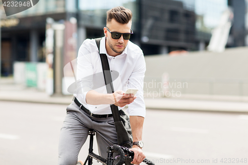 Image of man with bicycle and smartphone on city street