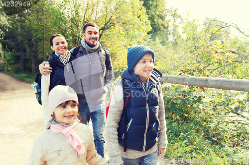 Image of happy family with backpacks hiking in woods