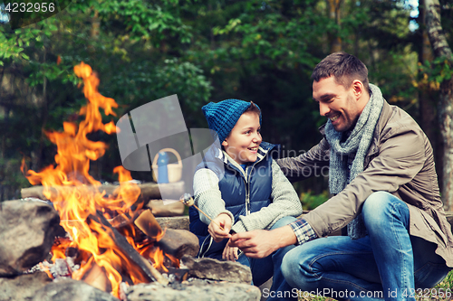 Image of father and son roasting marshmallow over campfire