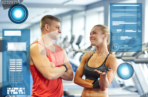 Image of smiling man and woman talking in gym