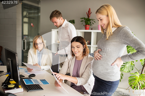 Image of happy business team with papers in office