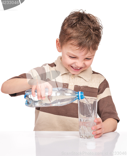 Image of Boy with glass and plastic bottle of water