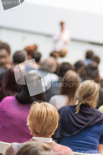 Image of Woman giving presentation in lecture hall at university.