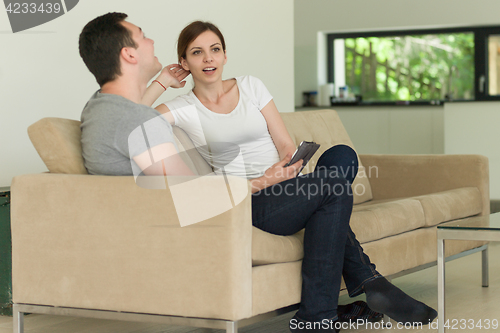 Image of couple relaxing at  home with tablet computers