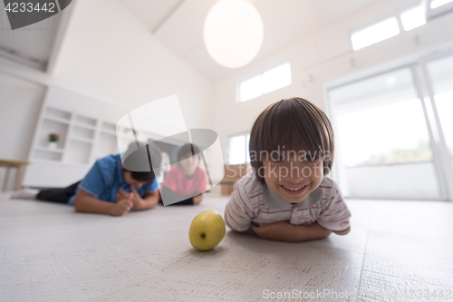 Image of boys having fun with an apple on the floor