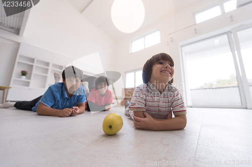 Image of boys having fun with an apple on the floor