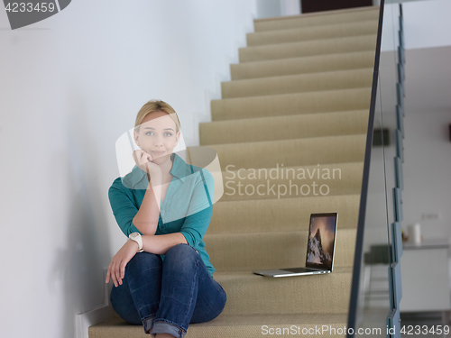 Image of portrait of a young beautiful woman on the stairs