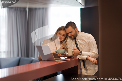 Image of A young couple is preparing for a job and using a laptop