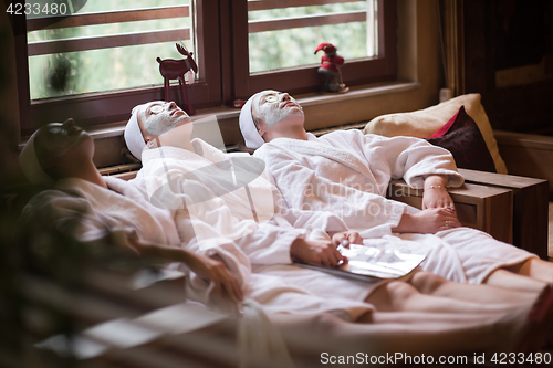 Image of women is getting facial clay mask at spa