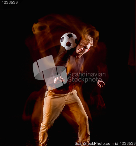 Image of A portrait of a fan with ball on gray studio background. Freestile