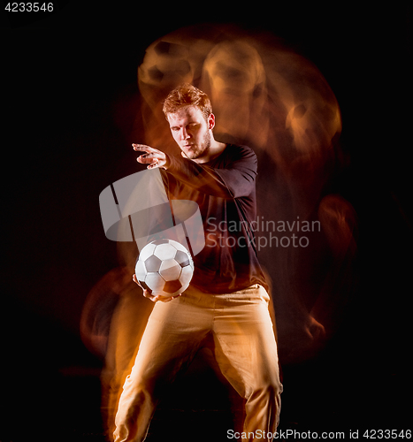 Image of A portrait of a fan with ball on gray studio background. Freestile