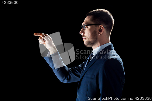 Image of businessman in suit over black