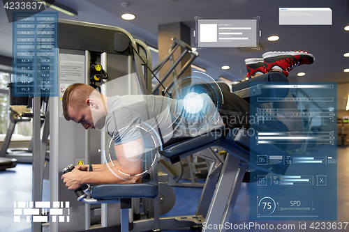 Image of man flexing leg muscles on gym machine