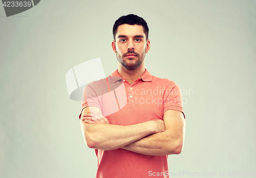 Image of young man with crossed arms over gray background