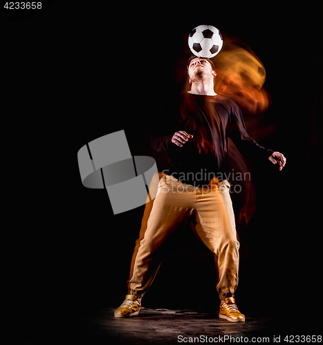 Image of A portrait of a fan with ball on gray studio background. Freestile