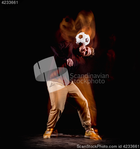 Image of A portrait of a fan with ball on gray studio background. Freestile