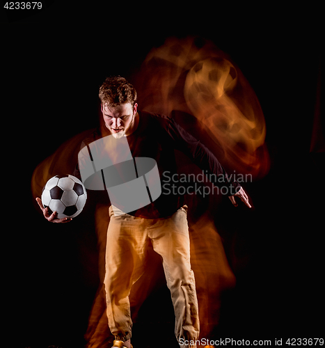 Image of A portrait of a fan with ball on gray studio background. Freestile