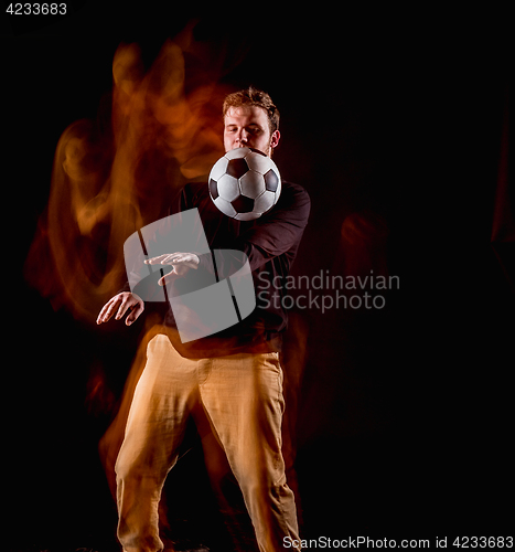 Image of A portrait of a fan with ball on gray studio background. Freestile