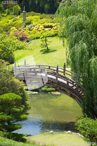 Image of Beautiful Japanese Garden with Pond and Bridge.