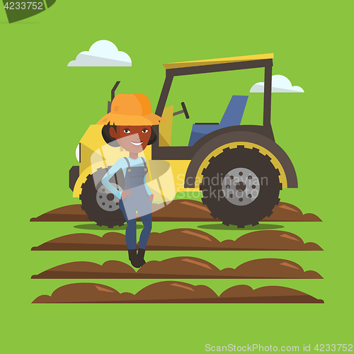 Image of Farmer standing with tractor on background.
