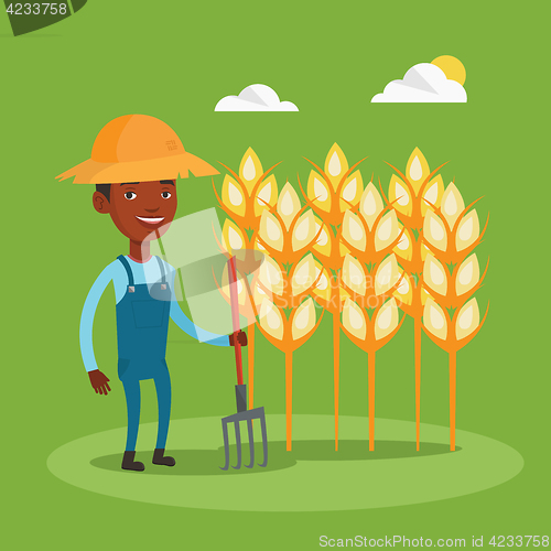 Image of Farmer with pitchfork at wheat field.