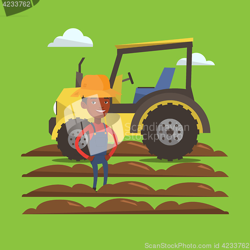 Image of Farmer standing with tractor on background.