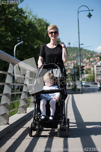 Image of mother pushed her baby daughter in a stroller