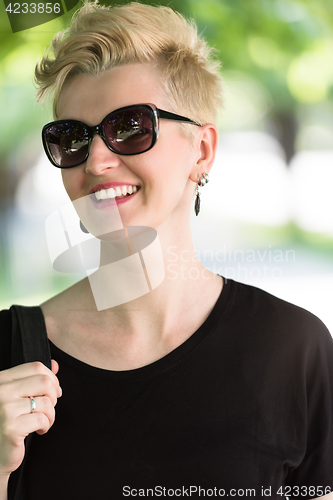 Image of young woman with short blond hair and sunglasses