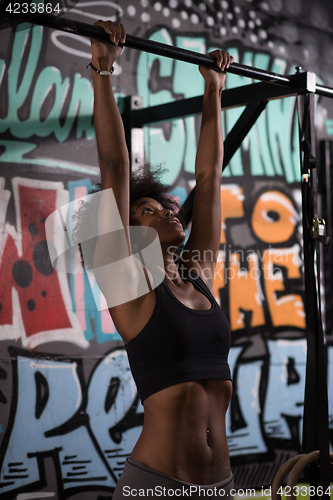 Image of black woman doing pull ups