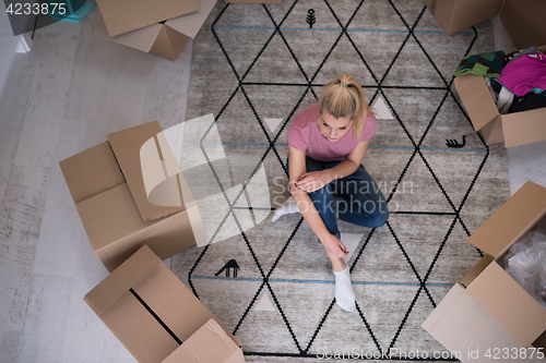 Image of top view of young beautiful woman sitting on the floor