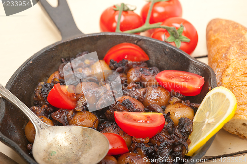 Image of Baby cuttle fish roasted on iron skillet