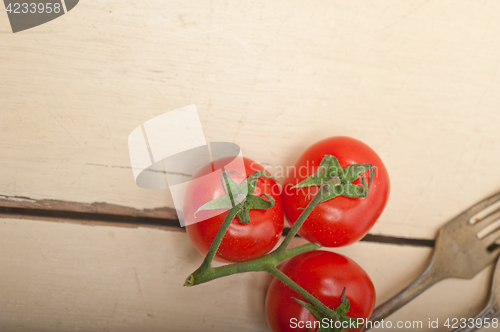 Image of ripe cherry tomatoes over white wood