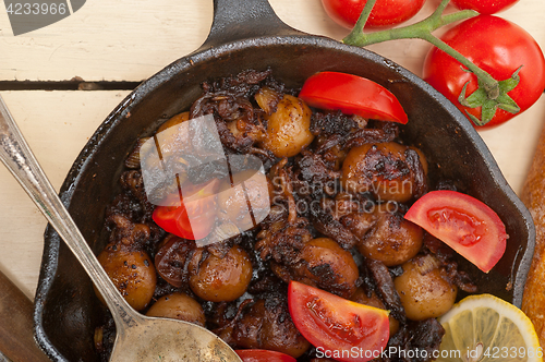 Image of Baby cuttle fish roasted on iron skillet