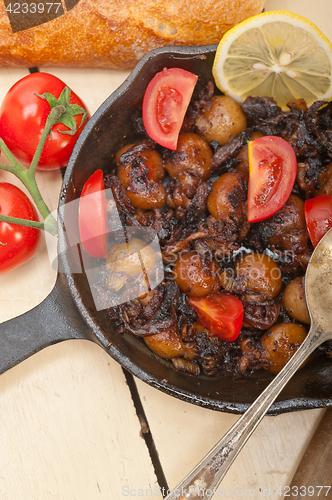 Image of Baby cuttle fish roasted on iron skillet