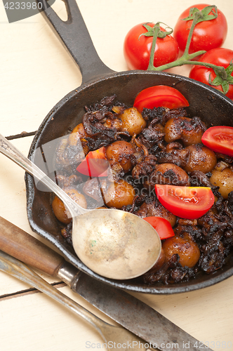 Image of Baby cuttle fish roasted on iron skillet