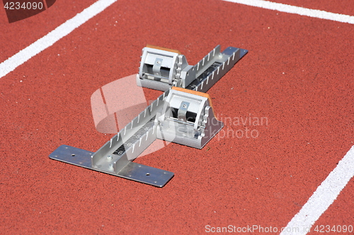 Image of Athletics starting blocks on race red track