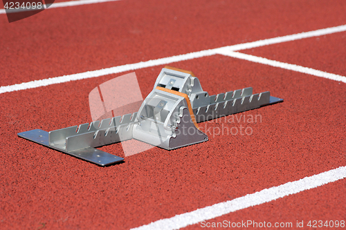 Image of Athletics starting blocks on race red track