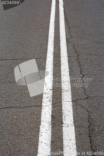 Image of Texture of an asphalt road with a top view of a double white strip