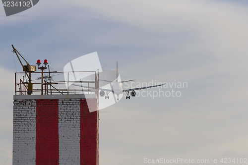 Image of Airplane landing to the airport over the building with lights